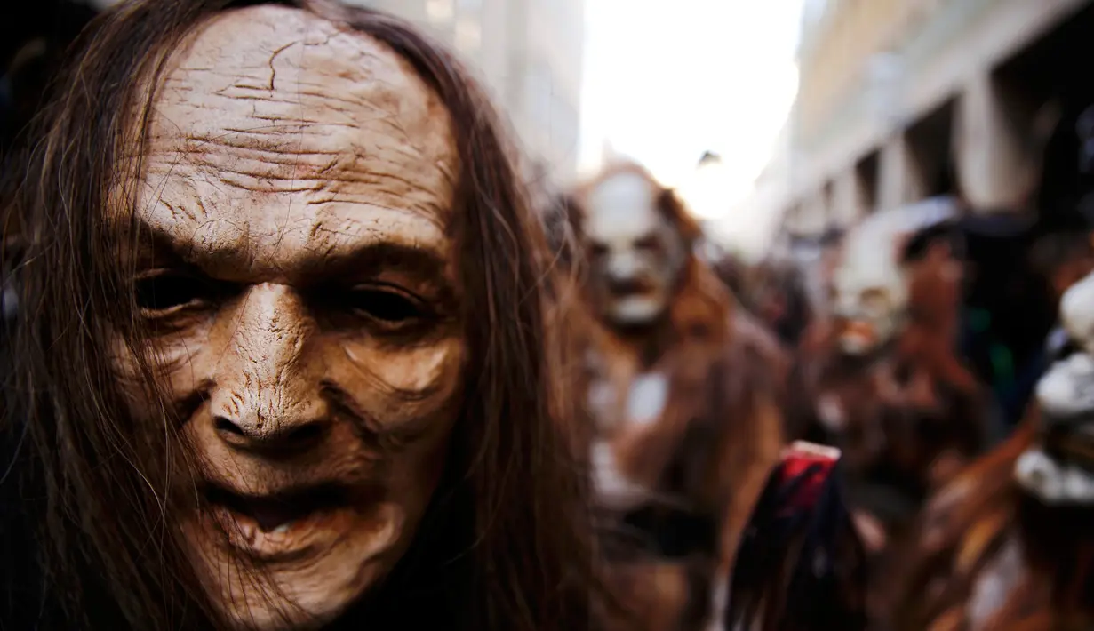 Sorang pria mengenakan kostum Krampuss selama parade di Munich, Jerman, Minggu (13/12). Menurut legenda setempat, Krampuss merupakan sosok iblis yang sangat menyeramkan. (REUTERS/Michael Dalder)