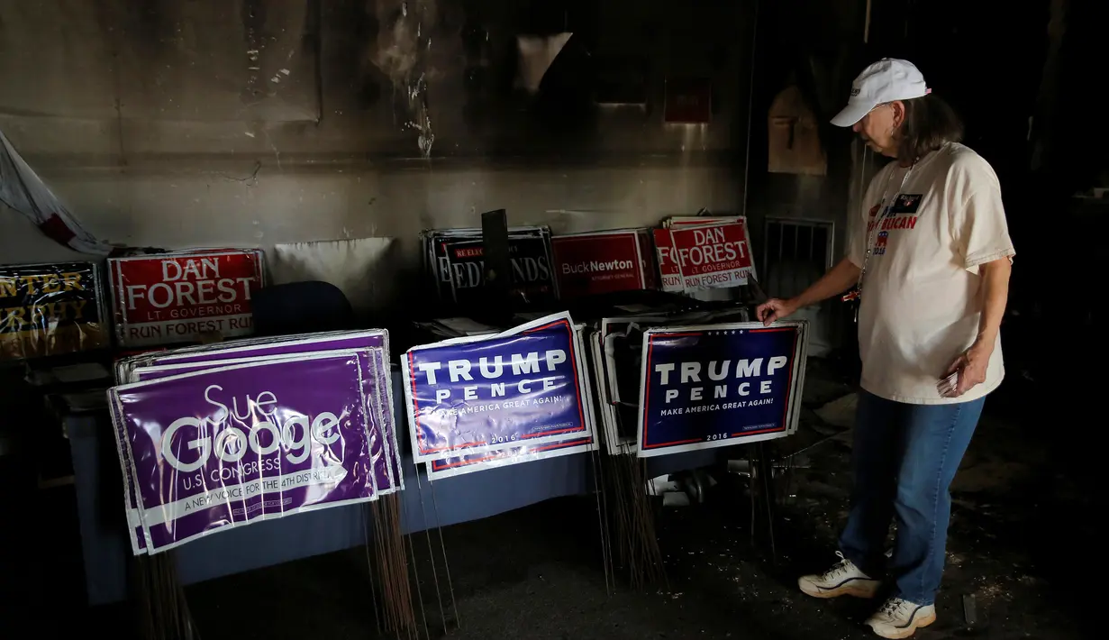Evelyn Poole-Kober mengamati kerusakan yang disebabkan serangan bom tangan di Kantor Partai Republik di North Carolina, AS, Senin (17/10). Kondisi bagian dalam kantor partai yang menaung capres Donald Trump itu hangus terbakar. (REUTERS/Chris Keane)