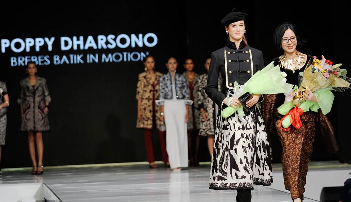 Poppy Dharsono terlihat berjalan diatas catwalk bersama dengan seorang model cantik di Jakarta Fashion dan Food Festival. Senin (19/5/2014) (Liputan6.com/Faizal Fanani)