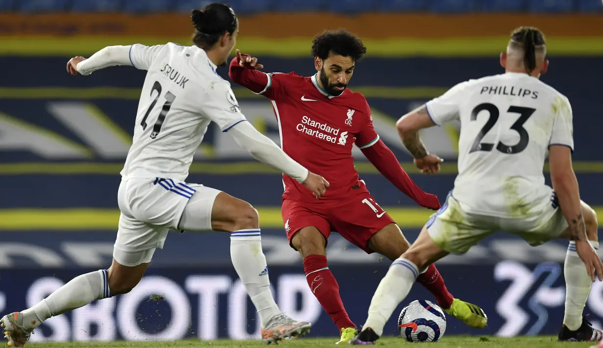 Pemain Liverpool Mohamed Salah (tengah) menggiring bola mencoba melewati pemain Leeds United Pascal Struijk (kiri) dan Kalvin Phillips pertandingan Liga Inggris di Stadion Elland Road, Leeds, Inggris, Senin (19/4/2021). Pertandingan berakhir dengan skor 1-1. (Paul Ellis/Pool via AP)