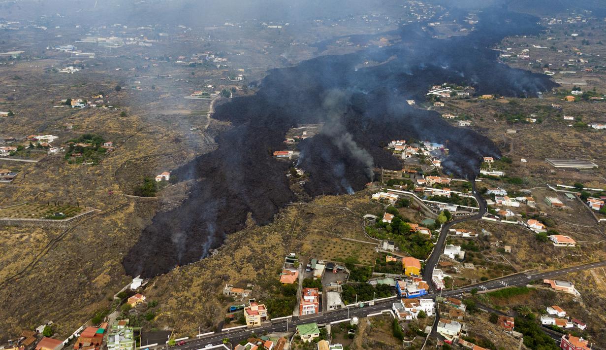 Lava dari letusan gunung berapi Cumbre Vieja mengalir menghancurkan rumah-rumah di pulau La Palma di Kepulauan Canary, Spanyol, Selasa (21/9/2021). Lava yang mengalir dari letusan gunung berapi itu memaksa evakuasi sekitar 5.500 orang dan menghancurkan sedikitnya 100 rumah. (AP/Emilio Morenatti)