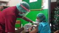Seorang Nakes di Kabupaten Sikka, takut saat jarum suntik vaksin covid-19 akan ditusuk ke lengannya. (Liputan6.com/Dionisius Wilibardus)