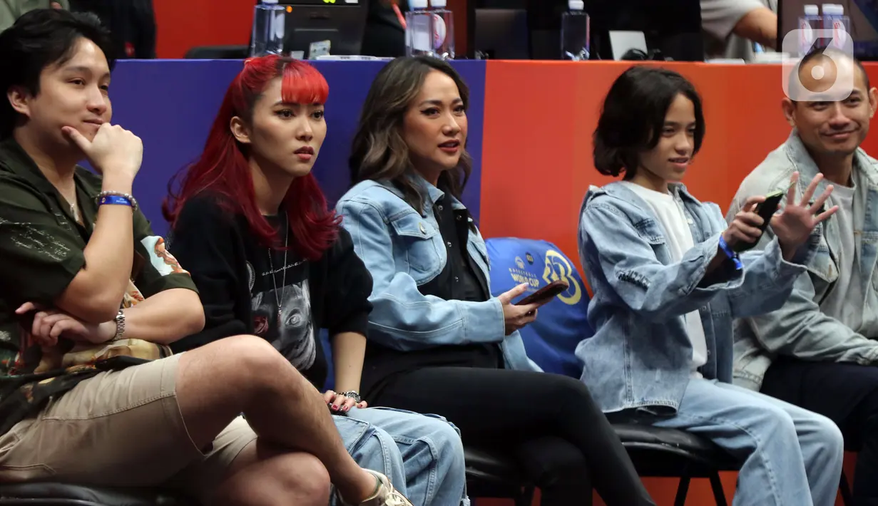 Penyanyi, Isyana Sarasvati (kedua kiri) dan Bunga Citra Lestari serius menyaksikan laga penutup penyisihan grup H FIBA World Cup 2023 antara Latvia dan Kanada di Indonesia Arena, Gelora Bung Karno, Jakarta, Selasa (29/8/2023). (Liputan6.com/Helmi Fithriansyah)