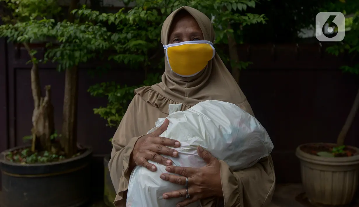 Warga menerima sembako i Kawasan Mako Paspampres,Jakarta, Rabu (15/4/2020). Donor daran dan pembagian sembako sebagai bentuk kepedulian kemanusian di tengah pandemi virus COVID-19. (merdeka.com/Imam Buhori)