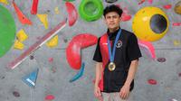 Atlet panjat tebing Indonesia, Veddriq Leonardo berfoto dengan medali emas Olimpiade Paris 2024 di markas FPTI, Hotel Santika Premier, Bekasi, Selasa (20/08/2024). (Bola.com/Bagaskara Lazuardi)