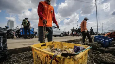 Petugas kebersihan membawa sampah laut di Pelabuhan Kali Adem, Jakarta, Senin (1/1). Banyaknya sampah plastik dibandingkan ikan yang gagal dikelola dengan baik membuat limbah yang mengakibatkan laut tercemar. (Liputan6.com/Faizal Fanani)