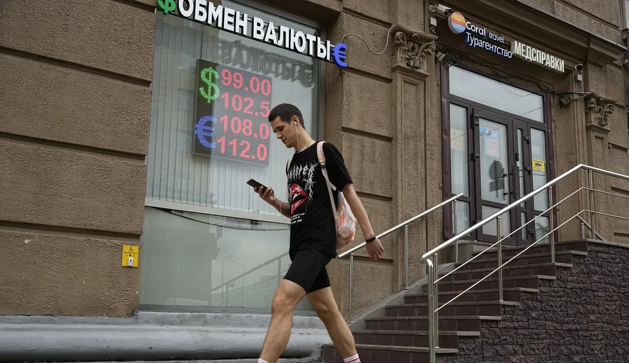 Seorang pria berjalan melewati kantor penukaran mata uang di Moskow, Rusia, Senin, 14 Agustus 2023.  (AP Photo/Alexander Zemlianichenko)