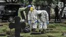Petugas menyemprotkan disinfektan di area makam pasien Covid-19 di TPU Pondok Kelapa, Jakarta, Selasa (13/7/2021). Tim Koalisi Warga LaporCovid-19 mencatat sebanyak 451 pasien Covid-19 meninggal saat menjalani isolasi mandiri. (merdeka.com/Iqbal S Nugroho)