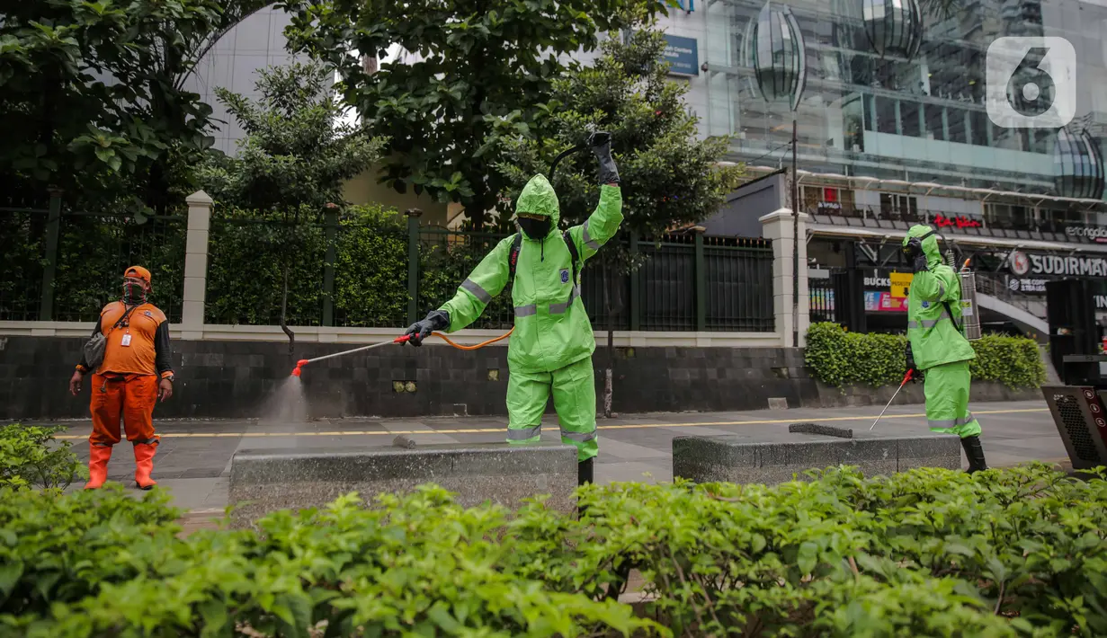 Petugas menyemprotkan cairan disinfektan di ruang publik kawasan pedestrian Sudirman, Jakarta, Kamis (19/3/2020). Penyemprotan dilakukan untuk antisipasi dan pencegahan penyebaran COVID-19 di lingkungan ruang publik yang banyak di gunakan oleh masyarakat. (Liputan6.com/Faizal Fanani)