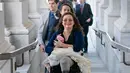 Senator negara bagian Illinois, Tammy Duckworth membawa bayinya ke ruangan kongres Gedung Capitol Hill, Washington DC, AS, Kamis (19/4). Duckworth (50) menggendong sang putri dalam pengambilan suara untuk nominasi pengurus NASA. (AP/J. Scott Applewhite)