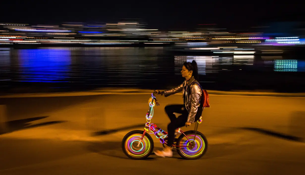 Seorang wanita mengendarai sepedanya dengan hiasan lampu saat berpartisipasi dalam acara Bike the Night di Vancouver, BC, (16/9). Penyelenggara mengharapkan lebih dari 5.000 orang untuk berpartisipasi dalam acara ini. (Darryl Dyck/Canadian Press via AP)