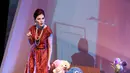 Memakai gaun pendek berwarna merah dengan hiasan kalung dan anting-anting mutiara, Olga Lydia menonjolkan gambaran seorang istri kedua sang pejabat. (Deki Prayoga/Bintang.com)