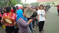 Ibu-ibu pedagang di pasar tradisional Kota Pekanbaru, berdemonstrasi sembari membawa kuali dan periuk. (Liputan6.com/M Syukur)