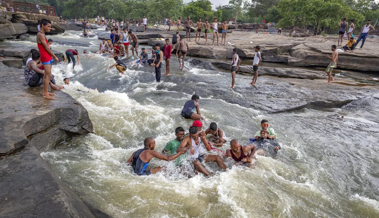 Orang-orang bermain di perairan Air Terjun Rajdari pada hari musim panas yang terik di distrik Chandauli, negara bagian Uttar Pradesh, India (28/6/2021).  Air Terjun Rajdari adalah tempat piknik yang populer bagi orang-orang di sekitar area tersebut pada musim panas. (AP Photo/Rajesh Kumar Singh)