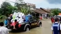 Untuk membantu masyarakat yang akan menyeberang, polisi menggunakan mobil patroli.
