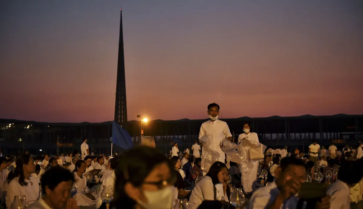 Umat Buddha mengenakan masker saat berdoa bersama di kuil Buddha Wat Dhammakaya, Bangkok (31/1/2020). Pemerintah Thailand mengumumkan 14 orang terkonfirmasi infeksi virus corona.Thailand memiliki jumlah kasus terbesar kedua di luar China. (AFP Photo/Lillian Suwanrumpha)