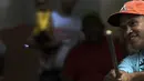 Seorang pemukul mengayunkan tutup botol saat memainkan permainan tradisional "chapitas" atau Caps, di Caracas, Venezuela, 29 Januari 2022. Permainan populer mirip dengan bisbol ini dimainkan dengan tutup botol sebagai pengganti bola, dan tongkat sebagai pengganti pemukul. (AP/Matias Delacroix)