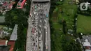 <p>Foto udara menunjukkan kendaraan terjebak macet di gerbang masuk tol Cikupa, Tangerang, Banten, Kamis (28/4/2022). Memasuki H-4 Hari Raya Idulfitri 1443 H atau Lebaran 2022, kendaraan pemudik dengan menggunakan kendaraan pribadi mengular di pintu tol Cikupa arah Merak. Kemacetan terjadi kurang lebih hingga dua km meter. (Liputan6.com/Angga Yuniar)</p>
