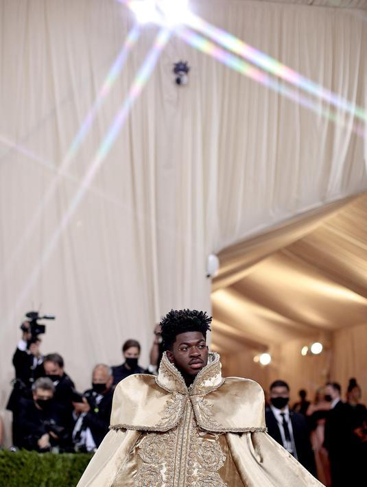 Penampilan Lil Nas X menghadiri The 2021 Met Gala Celebrating In America: A Lexicon Of Fashion di Metropolitan Museum of Art, New York City, Senin (13/9/2021). Lil Nas X yang hadir di Met Gala 2021 dengan penuh totalitas tampil menggunakan 3 busana sekaligus. (Dimitrios Kambouris/Getty Images/AFP)