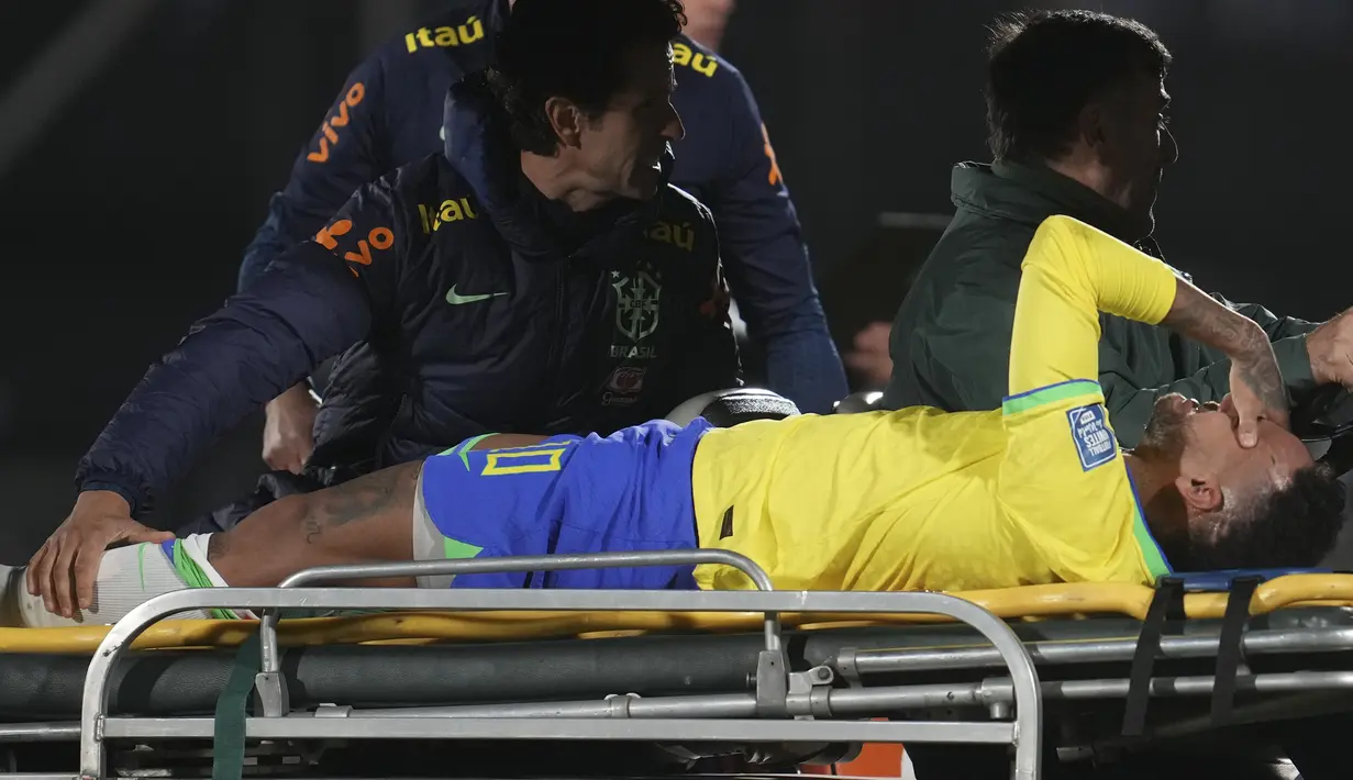 Penyerang Brasil Neymar dibawa keluar lapangan dengan tandu setelah cedera saat main tandang melawan Uruguay pada babak Kualifikasi Piala Dunia 2026 Zona Conmebol, di stadion Centenario di Montevideo, Rabu (18/10/2023). (AP Photo/Matilde Campodonico)