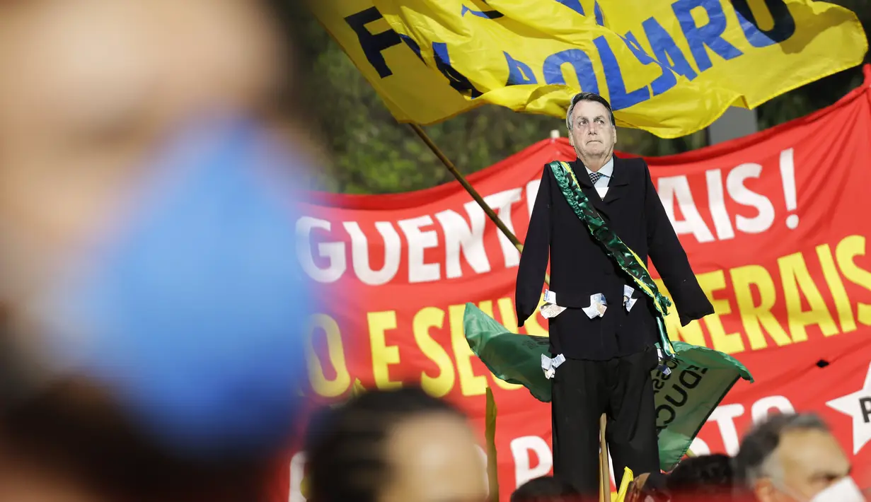 Potongan raksasa Presiden Brasil Jair Bolsonaro menjulang di atas demonstran yang berbaris di sepanjang Paulista Avenue di Sao Paulo, Sabtu (3/7/2021). Puluhan ribu orang turun ke jalan menuntut pemakzulan Presiden Jair Bolsonaro. (AP Photo/Nelson Antoine)