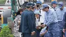 PM Jepang Shinzo Abe bertemu warga yang terkena dampak banjir saat mengunjungi wilayah Hita di prefektur Oita, Rabu (12/7). Abe menunjukkan keprihatinan dan berusaha untuk berinteraksi secara langsung dengan orang-orang di lokasi. (STR/JIJI PRESS/AFP)