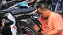 Mekanik memperbaiki motor di salah satu bengkel di Otista, Jakarta, Minggu (10/6). Calon pemudik motor mulai memenuhi bengkel guna menyervis atau mengganti suku cadang kendaraan sebelum digunakan untuk mudik Lebaran. (Liputan6.com/Angga Yuniar)