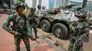 Personil TNI Yonif Mekanik 201 Kodam Jaya bersiaga di samping kendaraan taktis di Kawasan Bundaran Hotel Indonesia, Jakarta Pusat, Selasa (14/4/2105). KAA ke-60 akan berlangsung pada 18-24 April 2015 di Jakarta dan Bandung. (Liputan6.com/Faizal Fanani)