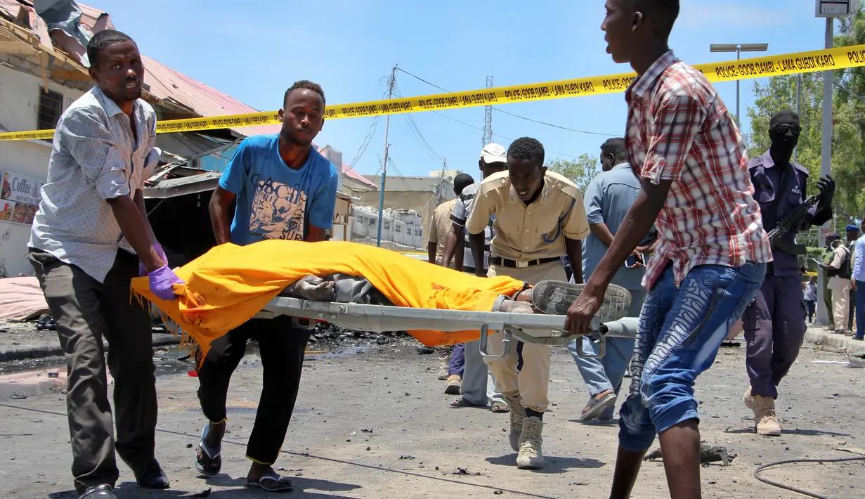Sejumlah pria membawa korban yang tewas akibat serangan bom mobil di sebuah restoran di Mogadishu, Somalia, Rabu (5/4). Ledakan bom mobil tersebut telah menewaskan sejumlah orang. (AP Photo / Farah Abdi Warsameh)