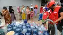 Petugas Palang Merah Indonesia (PMI) mengisi galon milik warga saat mendistribusikan bantuan air bersih di RW 10, Cipayung, Kota Depok, Kamis (14/9/2023). (merdeka.com/Arie Basuki)