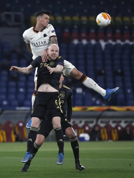 Bek AS Roma, Roger Ibanez berebut bola dengan gelandang Ajax Amsterdam, Davy Klaassen pada leg kedua perempat final Liga Europa di Olimpico, Jumat (16/4/2021) dini hari WIB. AS Roma melaju ke semifinal Liga Europa musim ini setelah bermain imbang 1-1 lawan Ajax. (AP Photo/Alessandra Tarantino)