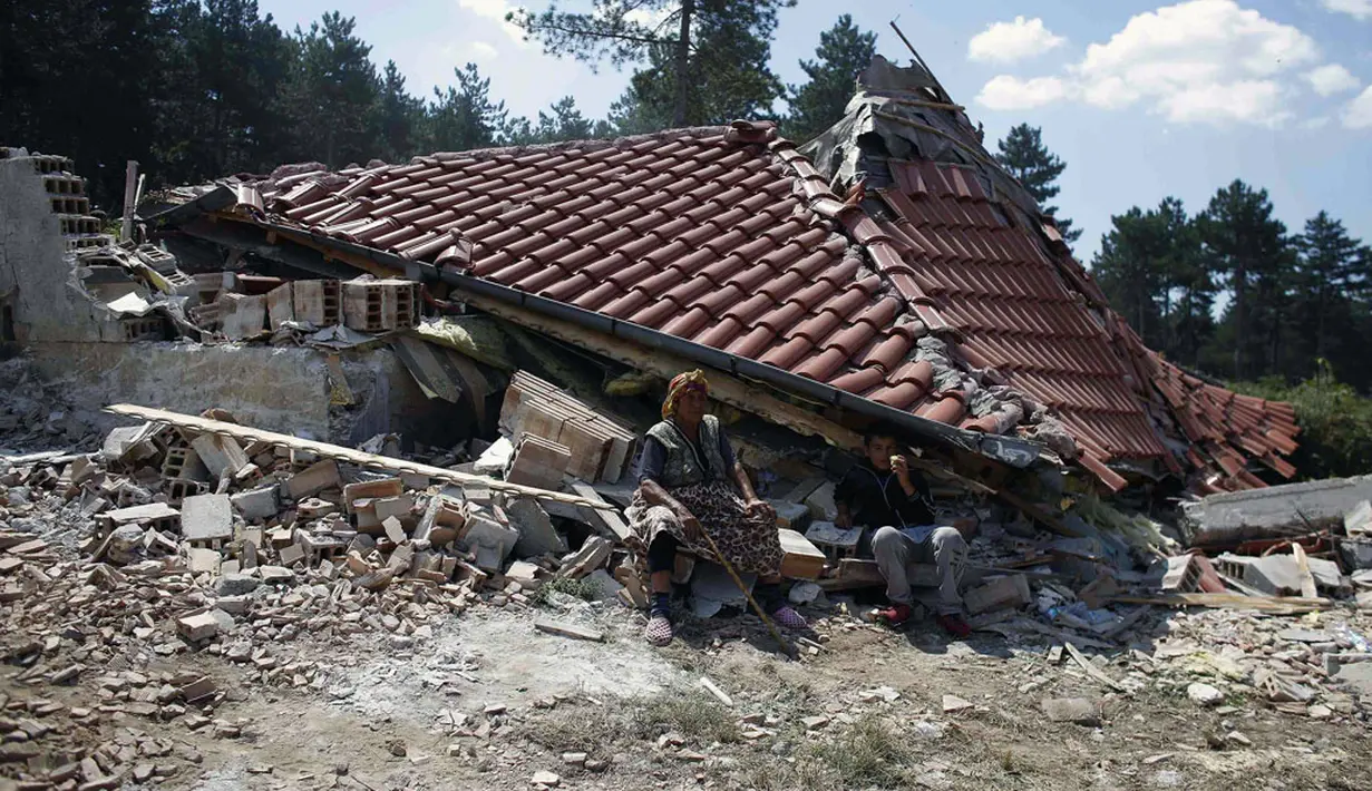 Salah satu warga pinggiran kota Roma, Stara Zagora, Bulgaria, terduduk di depan tempat tinggalnya yang nyaris rata dengan tanah karena dianggap ilegal, (21/7/2014). (REUTERS/Stoyan Nenov)