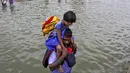 Seorang pria membawa seorang gadis melalui jalan banjir di Chennai, India, (2/11/2015). Curah hujan terparah dari satu abad telah menyebabkan banjir besar di seluruh negara bagian India Tamil Nadu. (REUTERS/Stringer)