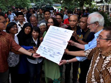 Sejumlah aktivis, tokoh agama dan masyarakat menunjukan Deklarasi "LBH Rumah Kita" di Pelataran Lembaga Bantuan Hukum (LBH) Jakarta, Senin (25/9). Pasca penyerangan, LBH membuka kantor dan gedung serta layanan Bantuan Hukumnya. (Liputan6.com/JohanTallo)