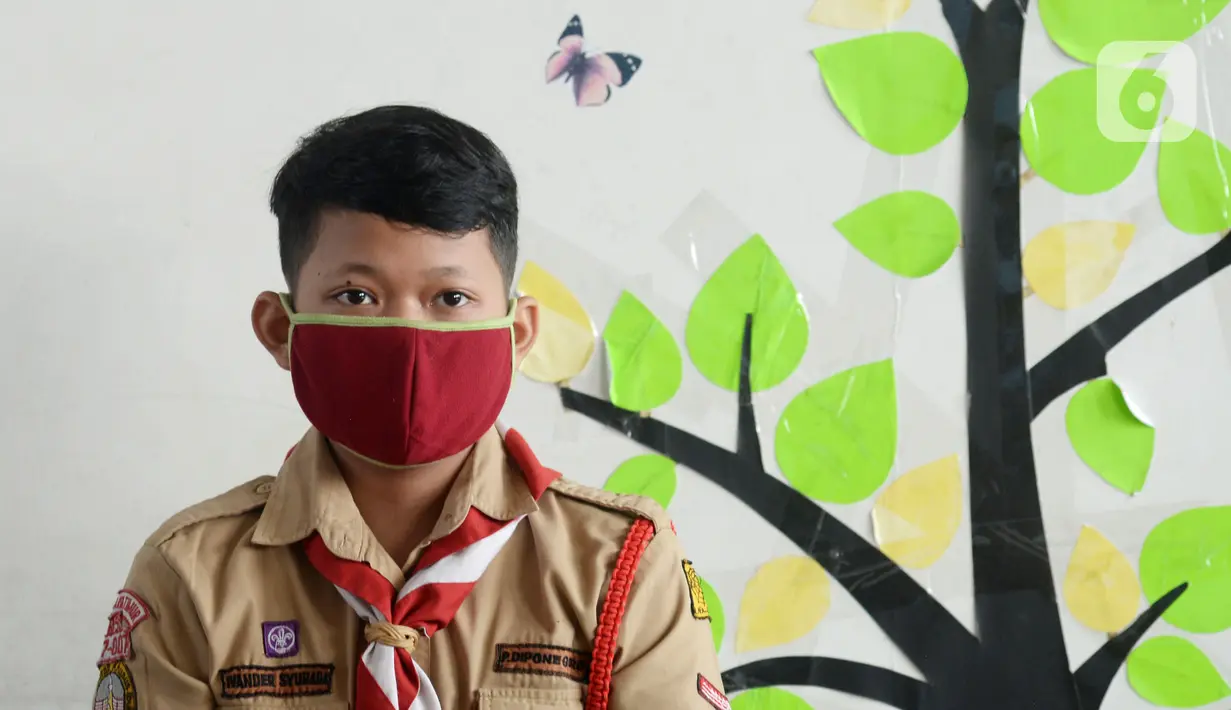 Seorang murid memakai masker saat uji coba pembelajaran tatap muka di SDN Malaka Jaya 07 Jakarta, Rabu (9/6/2021). Pembelajaran dilakukan secara campuran antara online (daring) dan tatap muka langsung. (merdeka.com/Imam Buhori)