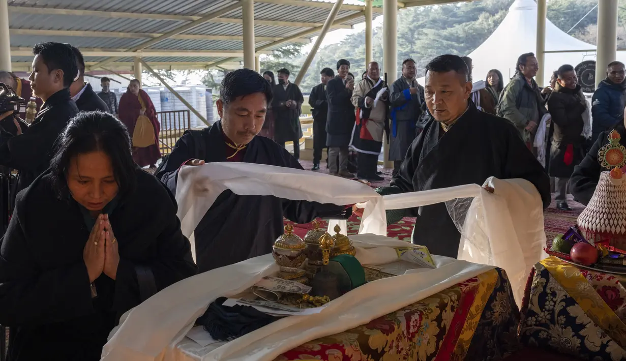 Warga Tibet di pengasingan mempersembahkan selendang di depan altar selama sesi doa pagi untuk menyambut Tahun Kelinci Air di Dharamshala, India, Selasa (21/2/2023). Dalam penanggalan tradisional Tibet setiap tahun memiliki binatang, unsur, dan angka. (AP Photo/Ashwini Bhatia)