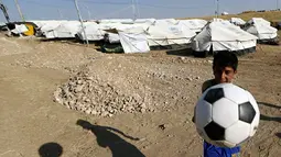 Bocah Sihite asal Irak bermain sepak bola. (AFP PHOTO/KARIM SAHIB)