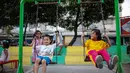 Anak-anak bermain ayunan di Ruang Publik Terbuka Ramah Anak (RPTRA) Rusun Petamburan, Jakarta, Selasa (9/10). Pemprov DKI Jakarta memangkas anggaran pembangunan RPTRA. (Liputan6.com/Faizal Fanani)