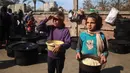 Krisis pangan di Gaza membuat pengungsi rela mengantri panjang berjam-jam di bawah terik matahari sambil berdesakan dengan yang lainnya. (Eyad BABA/AFP)