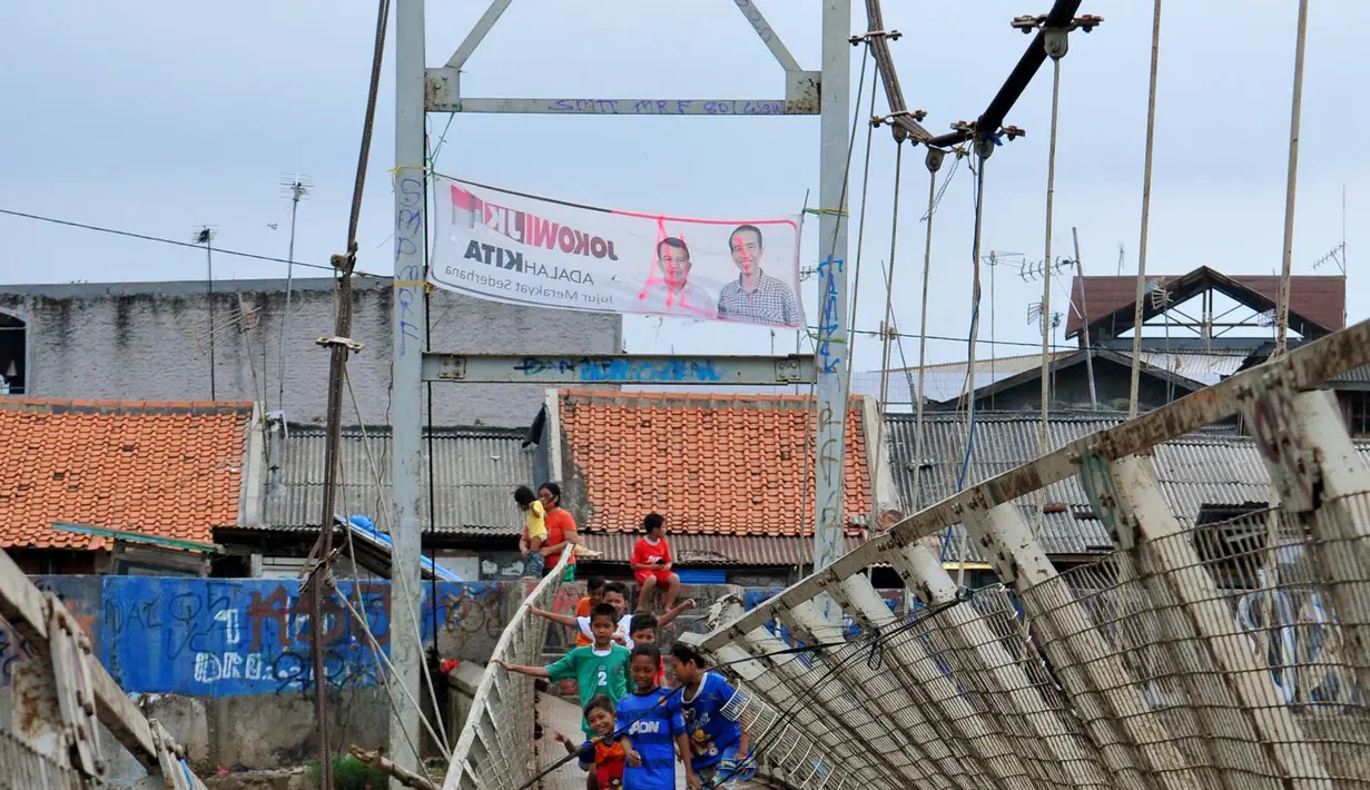 Sejumlah anak-anak melintas di Jembatan Gantung yang rusak di Petamburan, Jakarta Barat, Sabtu (14/06) (Liputan6.com/Andrian M Tunay)