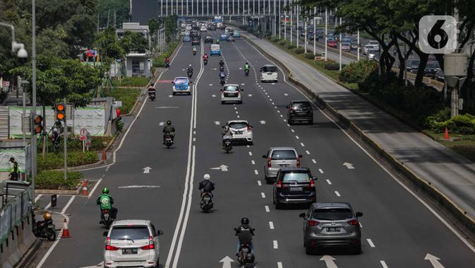 Sejumlah kendaraan melintasi Jalan Sudirman, Jakarta, Senin (13/4/2020). Hari ke-4 penerapan Pembatasan Sosial Berskala Besar (PSBB) di DKI yang dimulai sejak 10 April hingga 23 April 2020, arus lalu lintas di ruas jalan protokol  tersebut masih ramai kendaraan. (Liputan6.com/Faizal Fanani)