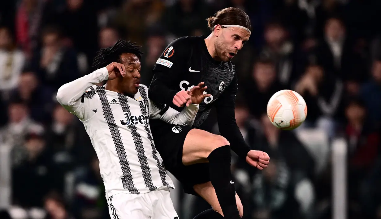 Bek Juventus, Juan Cuadrado (Kiri) dan pemain depan Freiburg, Lucas Hoeler berebut bola dalam laga leg pertama babak 16 besar Liga Europa 2022-2023 di Allianz Stadium, Jumat (10/3/2023) dini hari WIB. Juve membombardir barisan bek lawan dengan tembakan-tembakan keras, tapi Freiburg menunjukkan pertahanan solid. (Photo by Marco BERTORELLO / AFP)