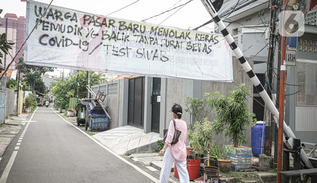 Pejalan kaki melintas di bawah spanduk peringatan untuk pemudik di kawasan Kartini, Sawah Besar, Jakarta, Senin (17/5/2021). Spanduk tersebut untuk memperingati warga yang kembali dari mudik lebaran agar membawa surat bebas COVID-19. (Liputan6.com/Faizal Fanani)
