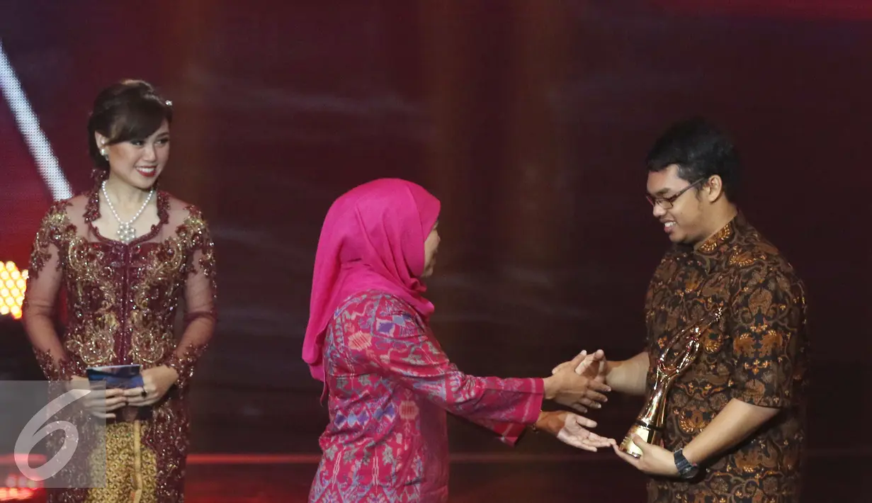 Menteri Sosial Khofifah Indar Parawansa memberikan piala penghargaan kepada Risqi dan Tim Kategori Kreasi Digital dalam ajang Liputan6 Awards 2016 SCTV di Studio 6 Emtek City, Jakarta, Kamis (26/5/2016). (Liputan6.com/Herman Zakharia)