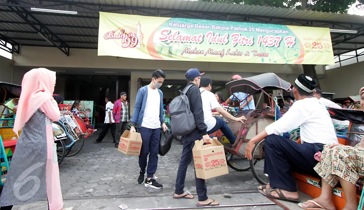 Wisatawan tampak menaiki becak usai berbelanja di pusat oleh-oleh bakpia pathok,Yogyakarta,(10/7). Oleh-oleh khas Yogyakarta, Bakpia pathok menjadi favorit wisatawan untuk dibawa pulang. (Boy Harjanto)