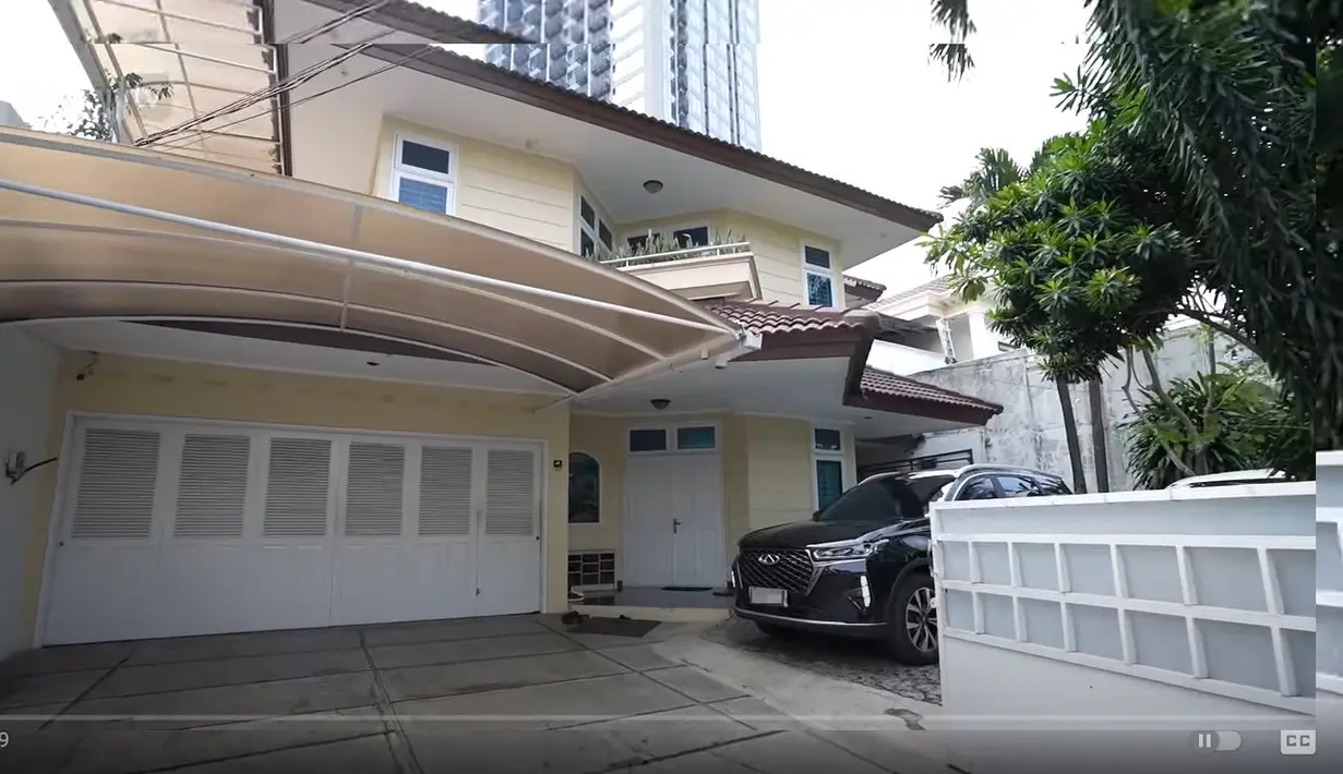Tampak depan rumah kedua pria yang namanya melejit dari grup komedian Cagur. Halaman depan masih tampak luas bisa parkir beberapa mobil. Dan terdapat taman area hijau. [Youtube/Taulany TV]