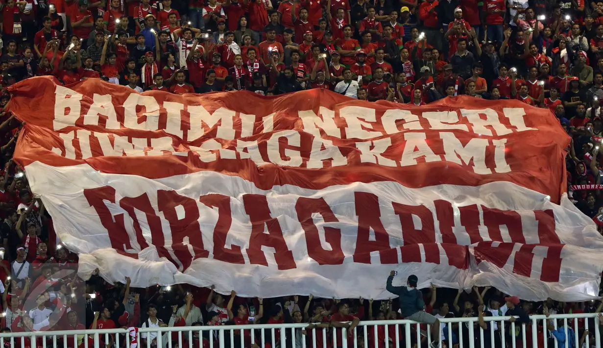 Suporter membentangkan bendera raksasa saat menyaksikan laga Timnas Indonesia melawan Vietnam pada semifinal pertama Piala AFF 2016 di Stadion Pakansari, Bogor, Sabtu (3/12). Indonesia unggul 2-1 atas Vietnam. (Liputan6.com/Helmi Fithriansyah)