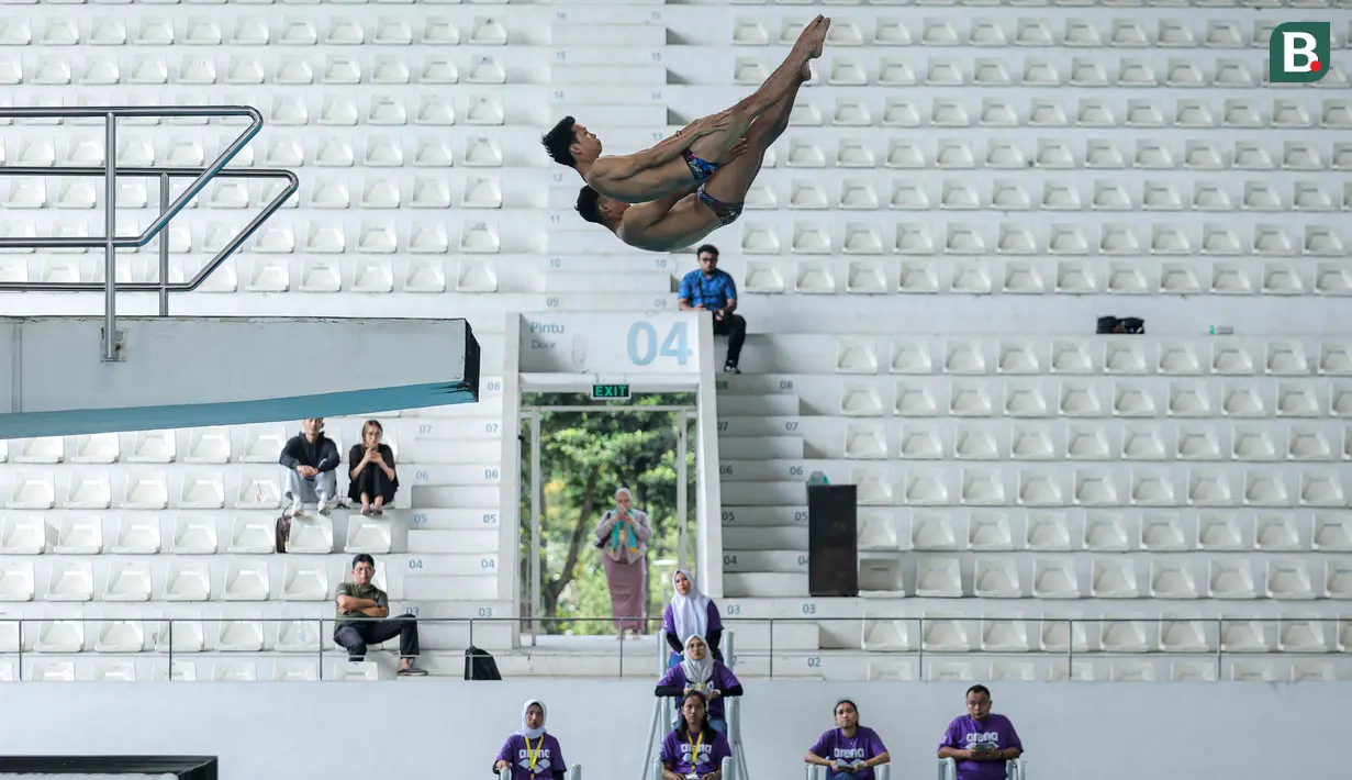 Pasangan atlet loncat indah, Andriyan (atas) dan Adityo Restu Putra melakukan loncatan pada nomor menara synchro putra Kejurnas Akuatik 2026 di Stadion Akuatik Gelora Bung Karno, Senayan, Jakarta, Selasa (05/05/2026). (Bola.com/Bagaskara Lazuardi)