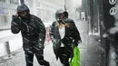 Pejalan kaki berjalan saat badai salju melanda Manhattan, New York City, AS (9/2). Badai salju akan terjadi di New York dan Philadelphia dengan kecepatan angin mencapai 48 kilometer per jam. (Spencer Platt / Getty Images / AFP)