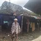 Seorang nenek melintas di depan rumahnya yang rusak atapnya karena diterjang bencana puting beliung yang kembali terjadi setelah 30 tahun. (Foto: Liputan6.com/Felek Wahyu)